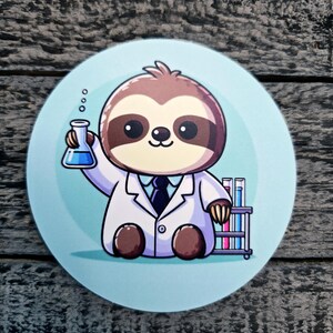 May include: A round sticker featuring a cartoon sloth wearing a white lab coat and a blue tie. The sloth is holding a beaker with blue liquid and is sitting next to a rack of test tubes.