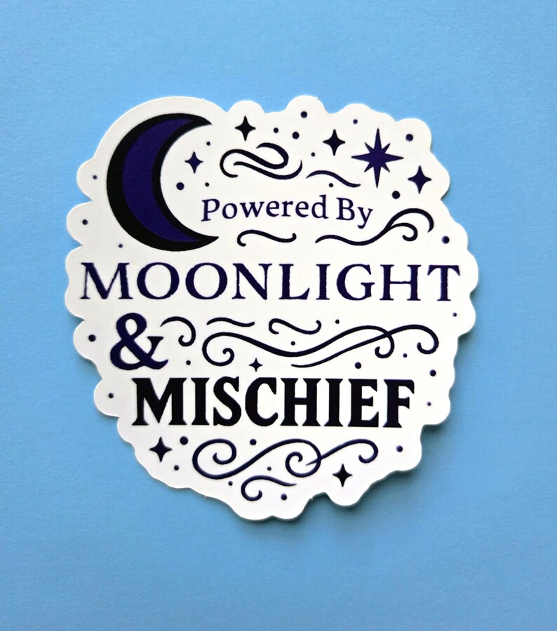 May include: A white sticker with a scalloped edge, featuring the text "Powered By Moonlight & Mischief" in a dark blue font. The design includes a crescent moon, stars, and decorative swirls on a light blue background.