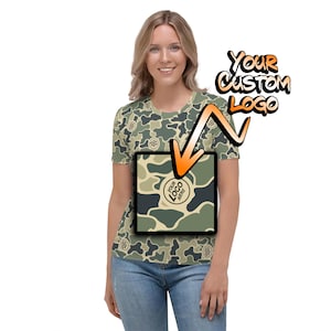 May include: A woman wearing a short-sleeved camouflage pattern t-shirt and blue jeans. The shirt has a green, tan, and black pattern. An arrow points to a square with a circular logo that says "Your Logo Here". The words "Your Custom Logo" are above the arrow.