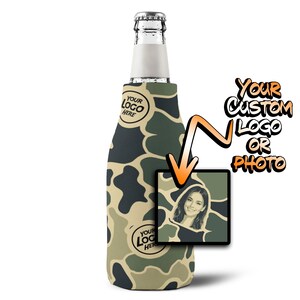 May include: A bottle cooler sleeve featuring a camouflage pattern in shades of green, tan, and black. The sleeve includes circular placeholders labeled 'YOUR LOGO HERE' and a square inset showing a portrait photo with an orange arrow pointing to it.