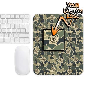 May include: A green and brown camouflage mouse pad with a square space for a logo. The text "YOUR CUSTOM LOGO" is in orange letters on a white background.