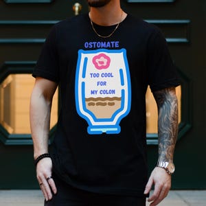 May include: Black t-shirt with a graphic of a colostomy bag with the text "Ostomate Too Cool For My Colon".