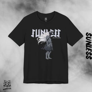 Puede incluir: Camiseta negra con la palabra "SUNLESS" en una fuente estilizada, y una ilustración de una figura con pelo largo blanco y armadura oscura. El texto "LORD OF SHADOWS" está debajo de la palabra "SUNLESS". El logotipo de la marca está en la parte inferior.
