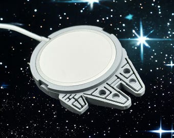 Puede incluir: Un modelo de plástico gris del Millennium Falcon, la nave espacial de Star Wars. El modelo tiene un centro redondo blanco y un diseño detallado de las alas y la cabina de la nave.