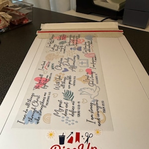May include: A clear sticker sheet featuring Christian affirmations and inspirational quotes. Phrases include "I can do all things" and "I am strong and courageous." The Rise Up Designs logo is at the bottom.