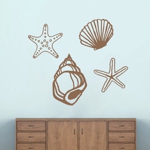 May include: A set of four brown wall decals featuring a seashell, a starfish, and two different types of seashells.