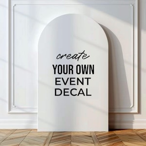 May include: A white, arched event decal with the text "create YOUR OWN EVENT DECAL" in black. The decal is set against a white wall with molding and a wooden floor.
