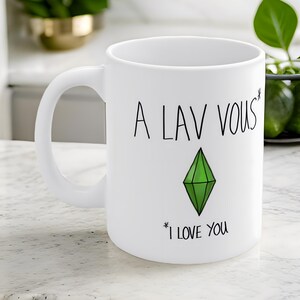 May include: White ceramic mug with a green diamond and the text "A lav vous* I love you".