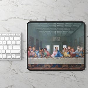 May include: A rectangular mouse pad featuring a parody of The Last Supper with characters from The Office. The scene depicts the cast seated at a long table in a room with the Dunder Mifflin logo on the wall. The print uses muted blue and earth tones.