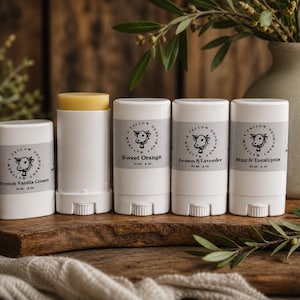 May include: Five white cylindrical deodorant containers with grey labels featuring a cow illustration and the text Matthew's Tallow Deodorant. Scents include French Vanilla Cream, Sweet Orange, Lemon & Lavender, and Mint & Eucalyptus, each 2 oz.