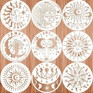 May include: Nine circular stencils with celestial designs. Each stencil features a sun, moon, stars, and other celestial elements. The stencils are white and set against a wooden background. The designs include faces, trees, and decorative patterns.