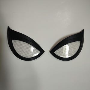 May include: A pair of black plastic Spider-Man eye lenses with white mesh inserts.