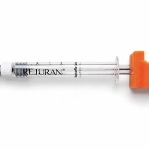 May include: A clear plastic syringe with a white cap on one end and a bright orange plastic plunger handle on the other. The barrel of the syringe features the black text REJURAN printed clearly along the side with measurement markings.