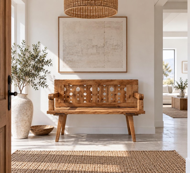 May include: A wooden bench with a high backrest featuring a repeating geometric cutout pattern of circles and diamonds. The bench has straight armrests and four angled legs, crafted from light brown wood with a visible grain and smooth finish.