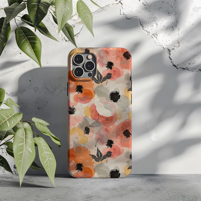 May include: A phone case with a floral design featuring watercolor-style pink, orange, and yellow flowers on a cream background. The case has a black camera cutout and a black outline.
