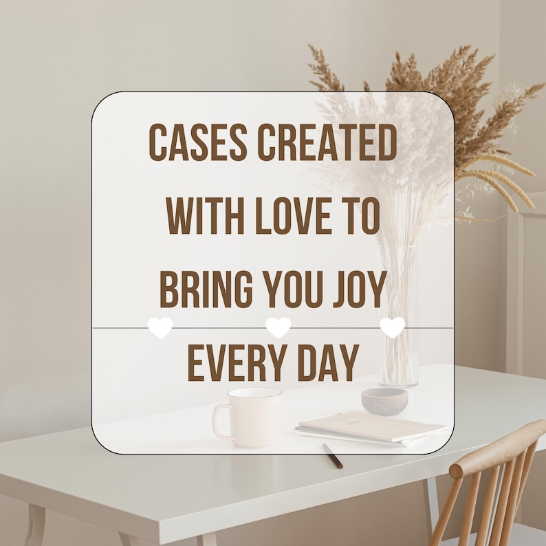 May include: A white square with brown text that reads "Cases Created with Love to Bring You Joy Every Day". The text is surrounded by three white hearts. The square is on a white table with a white mug, a notebook, and a pencil.