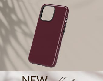 Puede incluir: Funda de teléfono burdeos brillante con un contorno negro para la cámara y botones laterales. El texto "NEW collection" se muestra en la parte inferior de la imagen. Fabricada en plástico duro.