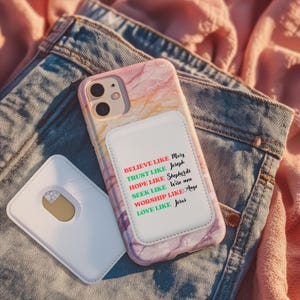 May include: A marble-patterned phone case with a white card holder attached, featuring the text "BELIEVE LIKE Mary, TRUST LIKE Joseph, HOPE LIKE Shepherds, SEEK LIKE Wise men, WORSHIP LIKE Ange, LOVE LIKE Jesus". A separate white card holder is also visible.