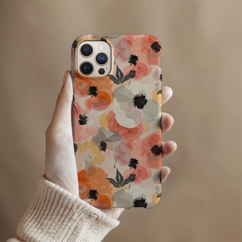 May include: A phone case with a floral pattern featuring pink, orange, and white flowers with black accents. The case has a cutout for the camera lens.