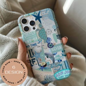 May include: A phone case with a beach-themed design. The case features a collage of seashells, starfish, a dolphin, and text including "Ron Jon Surf Shop" and "Beach Bum". The color palette includes shades of blue, white, and beige.