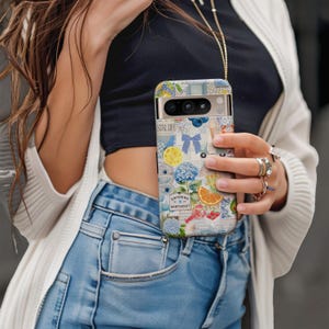 May include: A patterned phone case featuring a collage of images including a lemon, orange slice, blue flowers, and the text "Entering Nantucket". The case has a gold-colored frame and a lanyard.