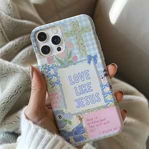 May include: A light blue and white patterned phone case with the text "LOVE LIKE JESUS". The case features a floral cross, bows, and the quote "God is within her, She will not fail - psalm 46:5".