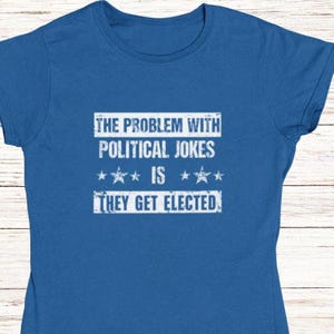 May include: A royal blue t-shirt with a white distressed graphic that reads "The problem with political jokes is they get elected."