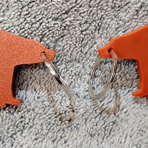 Un llavero personalizado de oso impreso en 3D, resistente y ligero. Perfecto para amantes de la naturaleza, aficionados a las actividades al aire libre o como accesorio único.