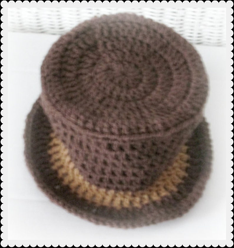 May include: A brown crocheted hat with a tan brim. The hat is made with a textured stitch.