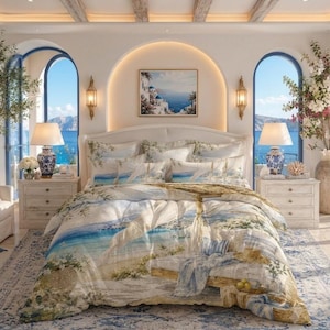 Op de afbeelding: Een beddengoedset met een kusttafereel met een zandstrand, blauwe oceaan en witte architectuur. Het dekbedovertrek en de bijpassende kussenslopen tonen een bedrukt landschap van een terras aan zee met een houten bank en blauwe accenten.