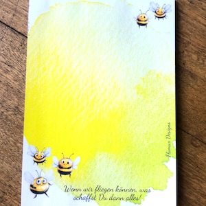 Può includere: Uno sfondo acquerellato giallo e verde con una citazione in tedesco che recita "Wenn wir fliegen können, was schaffst Du dann alles!"  Quattro api dei cartoni animati volano intorno al bordo dello sfondo acquerellato.