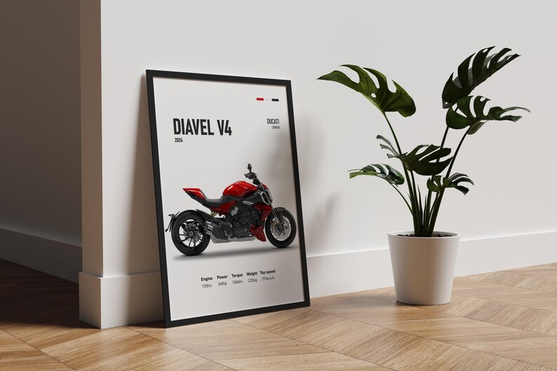Pu&ograve; includere: Un poster incorniciato in nero con sfondo bianco che presenta una moto Ducati Diavel V4 rossa. Il poster include il testo "Diavel V4" e "Ducati" insieme al motore, la potenza, la coppia, il peso e la velocit&agrave; massima della moto.