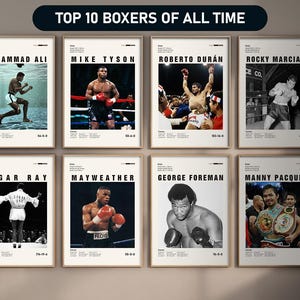 Puede incluir: Una colección de carteles enmarcados con los 10 mejores boxeadores de todos los tiempos. Cada cartel muestra una imagen en blanco y negro o en color de un boxeador, junto con su nombre y estadísticas de carrera. El título "TOP 10 BOXERS OF ALL TIME" está en la parte superior.