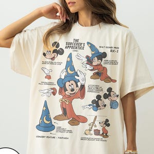 May include: Cream-coloured t-shirt with a vintage Mickey Mouse Sorcerer's Apprentice illustration. The design includes detailed drawings and text, with the words "The Sorcerer's Apprentice - 1940" and "Walt Disney Prod RX-1".