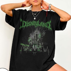 May include: Black t-shirt with a green graphic that says "Disneyland" in a gothic font. The graphic features a castle with fireworks in the background. The shirt is a relaxed fit.