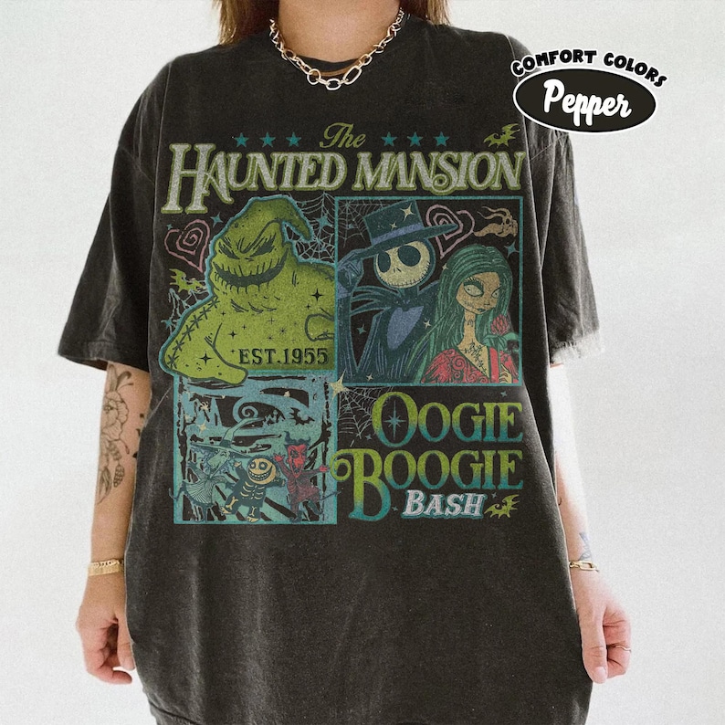 May include: Dark gray t-shirt featuring a graphic design with characters from The Haunted Mansion and the text "Oogie Boogie Bash." The design includes images of Jack Skellington, Sally, and Oogie Boogie. The shirt is labeled "Comfort Colors Pepper."