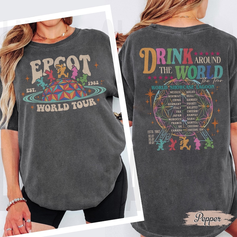 May include: Dark gray t-shirt with "EPCOT World Tour" graphic on the front, featuring a colorful planet design and the year 1982. The back of the shirt says "Drink Around The World" with a list of countries.