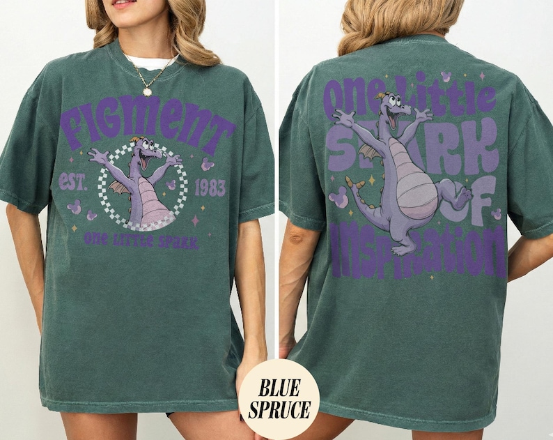 May include: A teal green t-shirt featuring a purple graphic of a cartoon dragon with the text "Figment" and "One Little Spark" on the front. The back of the shirt has a matching graphic and the text "One Little Spark of Imagination".