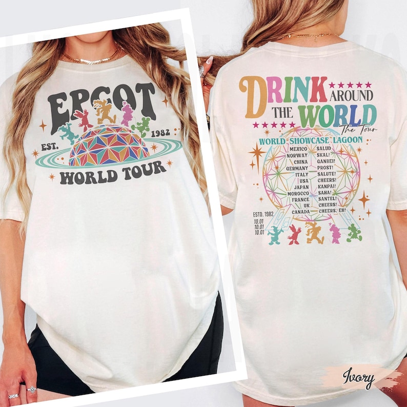 May include: Ivory-colored t-shirt featuring the text "EPCOT WORLD TOUR" with a retro design of a geodesic sphere and cartoon characters. The back of the shirt says "DRINK AROUND THE WORLD" with a list of countries and phrases.