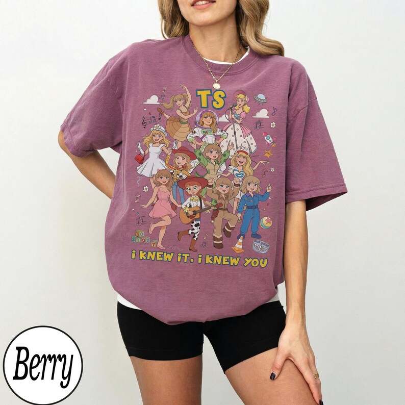 May include: A berry-colored short-sleeve t-shirt featuring a graphic print of multiple cartoon characters in various outfits. The text TS is printed at the top, and the text i knew it, i knew you is printed at the bottom in yellow lettering.