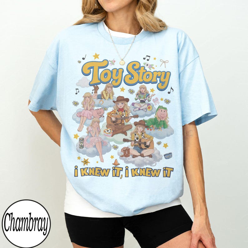 Może przedstawiać: Jasnoniebieski t-shirt z nadrukiem graficznym zawierającym tekst Toy Story oraz I KNEW IT, I KNEW IT. Wz&oacute;r przedstawia kilka ilustrowanych postaci w kowbojskich strojach siedzących na chmurach, otoczonych gwiazdami i nutami muzycznymi.