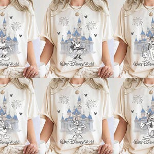 May include: Cream-coloured t-shirts featuring various Disney characters in front of Cinderella's castle with fireworks. The text "Walt Disney World" is printed below the castle. Characters include Mickey Mouse, Minnie Mouse, Goofy, Donald Duck, and Daisy Duck.