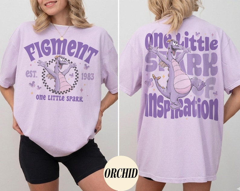 May include: A light purple t-shirt featuring a cartoon dragon with the text "Figment" and "one LITTLE spark" on the front. The back of the shirt has the text "one little spark of inspiration" and a matching dragon graphic.