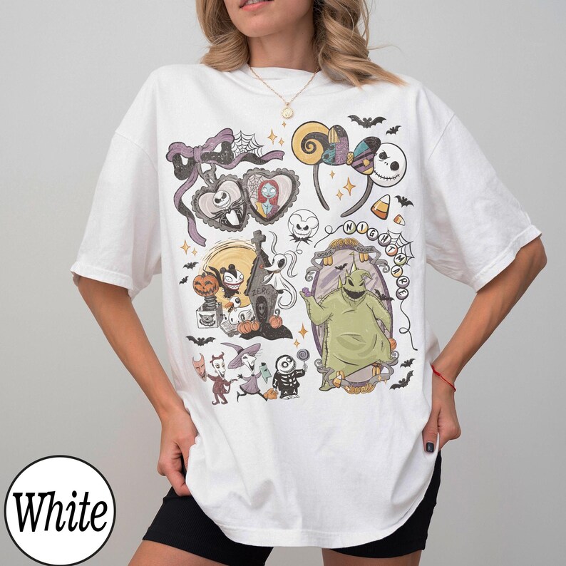 May include: White t-shirt featuring a colorful graphic design with characters and elements from the movie "The Nightmare Before Christmas." The design includes Jack Skellington, Sally, Oogie Boogie, and other iconic imagery. The shirt is a relaxed fit.