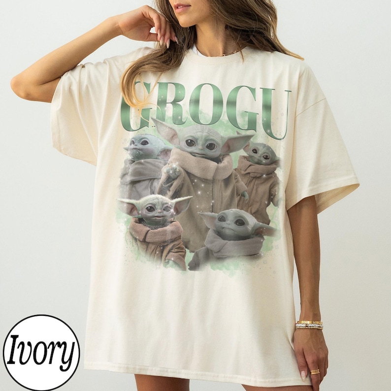 Puede incluir: Camiseta de color marfil con un gr&aacute;fico de Grogu de The Mandalorian. El dise&ntilde;o incluye m&uacute;ltiples im&aacute;genes de Grogu, con el nombre "GROGU" en verde arriba. La camiseta tiene mangas cortas y un corte relajado.