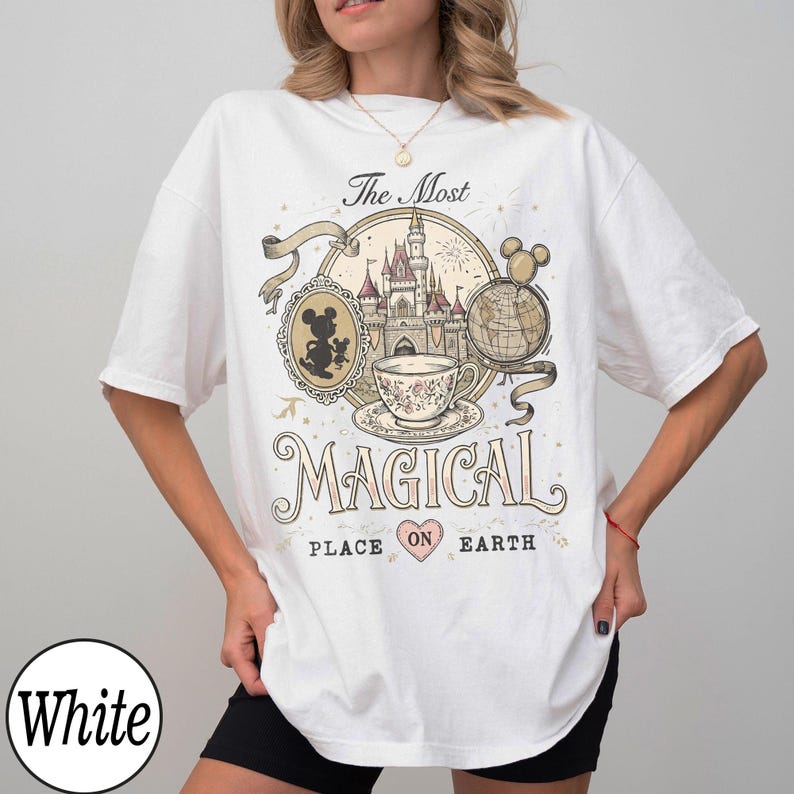May include: White t-shirt with a colorful graphic design featuring a castle, teacup, and Mickey Mouse. The text reads "The Most Magical Place on Earth."