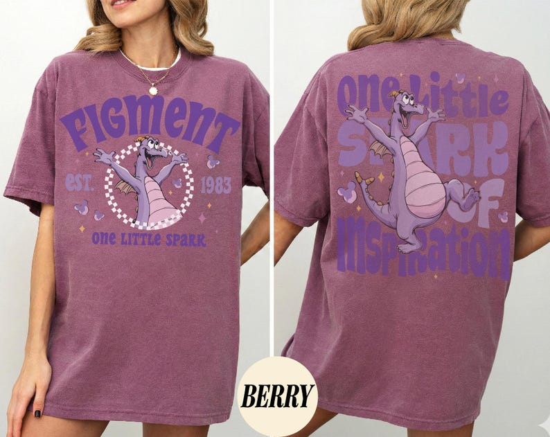 May include: Berry-colored t-shirt featuring a purple dragon graphic with the text "Figment" and "One Little Spark" on the front. The back of the shirt has a matching dragon graphic and the text "One Little Spark of Inspiration."