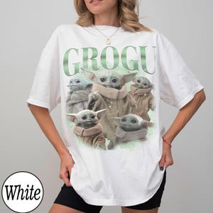 Puede incluir: Camiseta blanca con la palabra "GROGU" en verde y un gr&aacute;fico de Grogu, el personaje de The Mandalorian. El dise&ntilde;o presenta m&uacute;ltiples im&aacute;genes del personaje. La camiseta tiene un corte holgado y oversize.