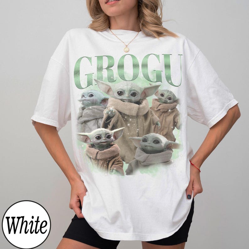 Puede incluir: Camiseta blanca con la palabra "GROGU" en verde y un gr&aacute;fico de Grogu, el personaje de The Mandalorian. El dise&ntilde;o presenta m&uacute;ltiples im&aacute;genes del personaje. La camiseta tiene un corte holgado y oversize.