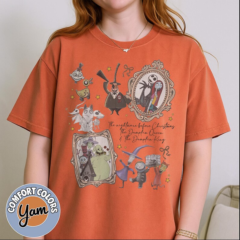 May include: Orange Comfort Colors t-shirt with a graphic design of characters from "The Nightmare Before Christmas." The design includes Jack Skellington, Sally, and other characters in ornate frames. The text reads "The Nightmare Before Christmas, The Pumpkin Queen & The Pumpkin King."